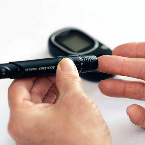 Diabetestest - Person testet ihr Blut mit einem elektronischen Diabetes-Test